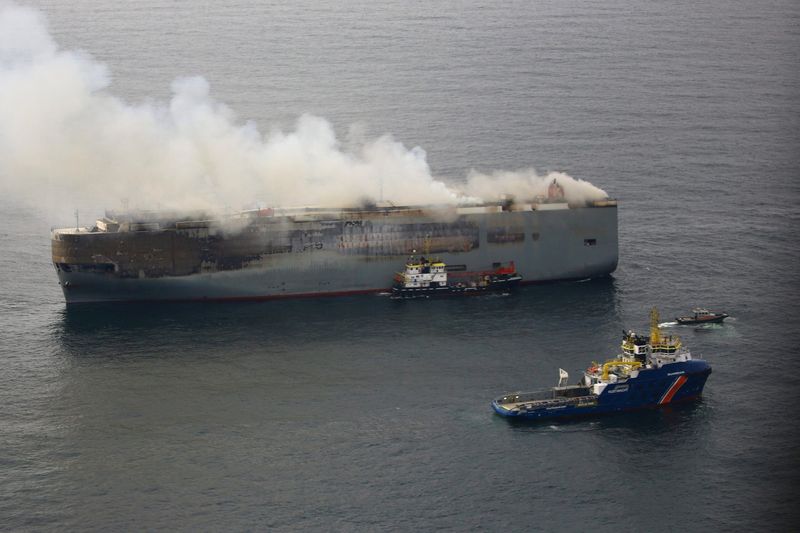Burning automotive carrier off Dutch cruise being towed some distance from shipping lanes